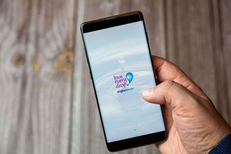 02-10-2021 Portsmouth, hampshire, UK A mobile phone or cell phone being held by a hand with the Anglian water app open on screenのeditorial素材