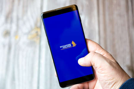 02-10-2021 Portsmouth, hampshire, UK A mobile phone or cell phone being held by a hand with the Singapore airlines app open on screenのeditorial素材