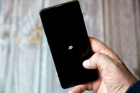 02-10-2021 Portsmouth, hampshire, UK A mobile phone or cell phone being held by a hand with the JD app open on screenのeditorial素材