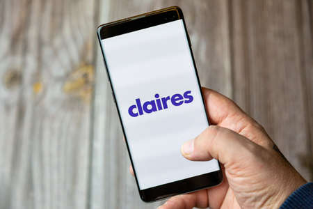 02-10-2021 Portsmouth, hampshire, UK A mobile phone or cell phone being held by a hand with the Claires app open on screenのeditorial素材