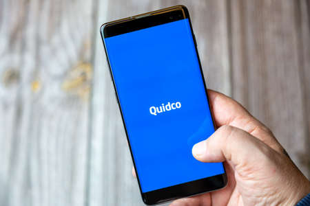 02-10-2021 Portsmouth, hampshire, UK A mobile phone or cell phone being held by a hand with the Quidco app open on screenのeditorial素材