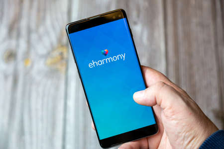 02-10-2021 Portsmouth, hampshire, UK A mobile phone or cell phone being held by a hand with the eHarmony online dating app open on screenのeditorial素材