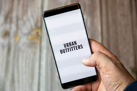 02-10-2021 Portsmouth, hampshire, UK A mobile phone or cell phone being held by a hand with the Urban Outfitters app open on screenのeditorial素材