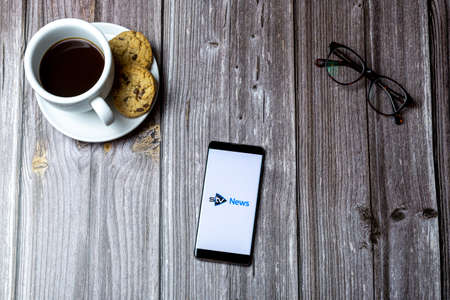 02-15-2021 Portsmouth, Hampshire, UK A mobile phone or cell phone laid on a wooden table with the STV news app open on screenのeditorial素材