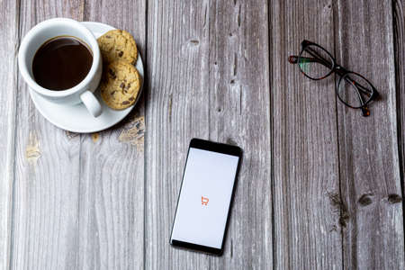 02-15-2021 Portsmouth, Hampshire, UK A mobile phone or cell phone laid on a wooden table with the app open on screenのeditorial素材