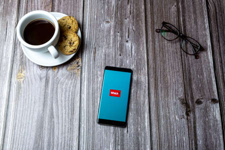 02-15-2021 Portsmouth, Hampshire, UK A mobile phone or cell phone laid on a wooden table with the Which app open on screenのeditorial素材