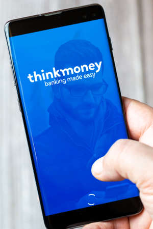 02-15-2021 Portsmouth, Hampshire, UK A mobile phone or cell phone being held in a hand with the think money app open on screenのeditorial素材