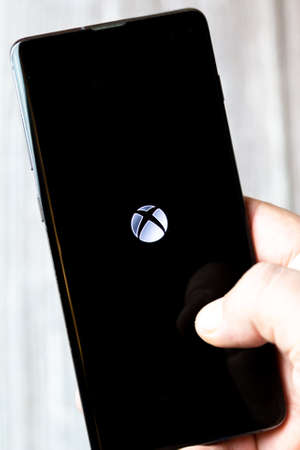 02-15-2021 Portsmouth, Hampshire, UK A mobile phone or cell phone being held in a hand with the Xbox live app open on screenのeditorial素材
