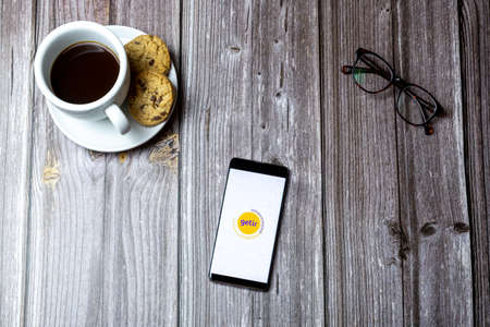 02-15-2021 Portsmouth, Hampshire, UK A mobile phone or cell phone laid on a wooden table with the Getir app open on screenのeditorial素材