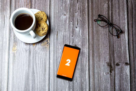 02-15-2021 Portsmouth, Hampshire, UK A mobile phone or cell phone laid on a wooden table with the BBC Radio 2 app open on screenのeditorial素材