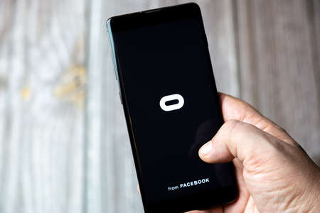 02-15-2021 Portsmouth, Hampshire, UK A mobile phone or cell phone being held in a hand with the oculus app open on screenのeditorial素材