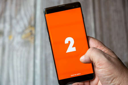 02-15-2021 Portsmouth, Hampshire, UK A mobile phone or cell phone being held in a hand with the Radio 2 app open on screenのeditorial素材