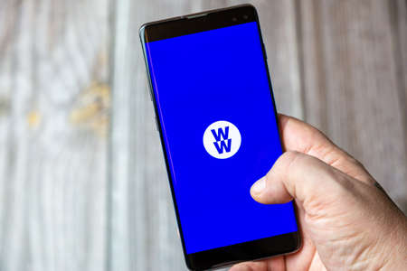 02-15-2021 Portsmouth, Hampshire, UK A mobile phone or cell phone being held in a hand with the WW or weight watchers app open on screenのeditorial素材