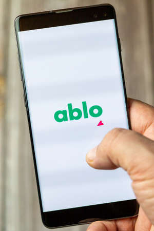 02-15-2021 Portsmouth, Hampshire, UK A mobile phone or cell phone being held in a hand with the ablo app open on screenのeditorial素材
