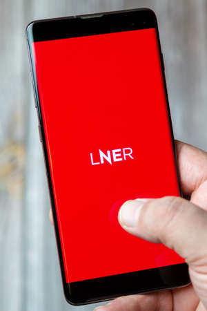 02-24-2021 Portsmouth, Hampshire, UK A mobile phone or cell phone being held by a hand with the LNER app open on screenのeditorial素材