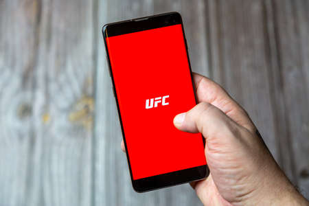 02-24-2021 Portsmouth, Hampshire, UK A mobile phone or cell phone being held by a hand with the UFC app open on screenのeditorial素材