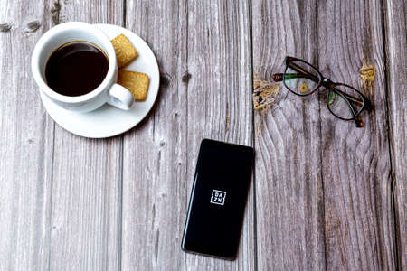 03-03-2021 Portsmouth, Hampshire, UK A mobile phone or cell phone laid on a wooden table with the Dazn live sports app open next to a coffeeのeditorial素材