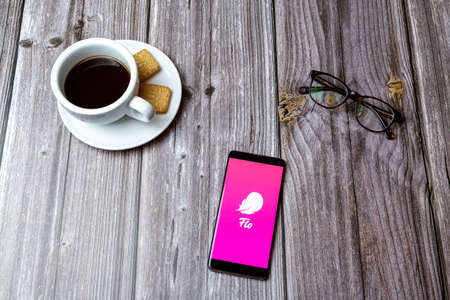 03-03-2021 Portsmouth, Hampshire, UK A mobile phone or cell phone laid on a wooden table with the Flo Period tracker app open next to a coffeeのeditorial素材