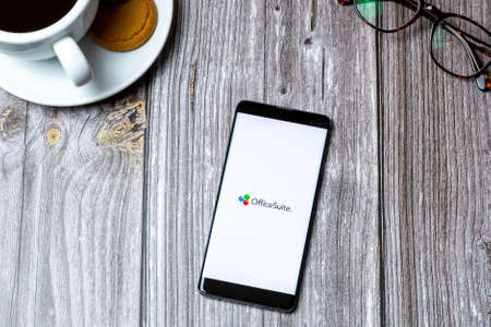 03-10-2021 Portsmouth, Hampshire, UK A Mobile phone or cell phone laid on a wooden table with the Office suite app open on screenのeditorial素材
