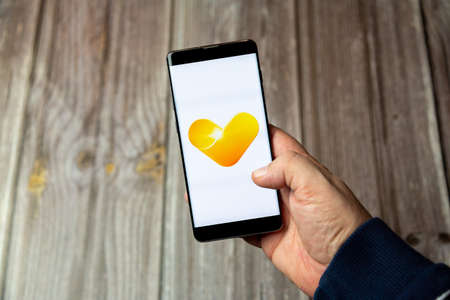 03-10-2021 Portsmouth, Hampshire, UK A Mobile phone or cell phone being held in a hand with the Thomas Cook app open on screenのeditorial素材