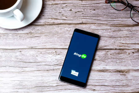 02-05-2021 Portsmouth, Hampshire, UK A mobile phone or cell phone laid on a wooden table or desk with the Ring Go app openのeditorial素材