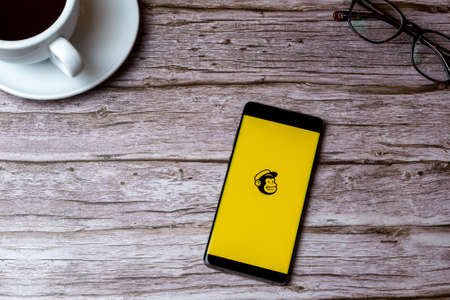 02-05-2021 Portsmouth, Hampshire, UK A mobile phone or cell phone laid on a wooden table or desk with the mailchimp app openのeditorial素材