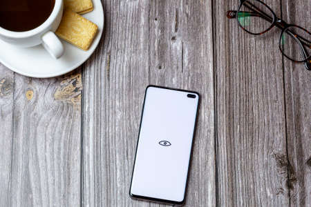 02-24-2021 Portsmouth, Hampshire, UK A mobile phone or cell phone on a wooden table with the Pure Hookup app open next to a coffee and glassesのeditorial素材