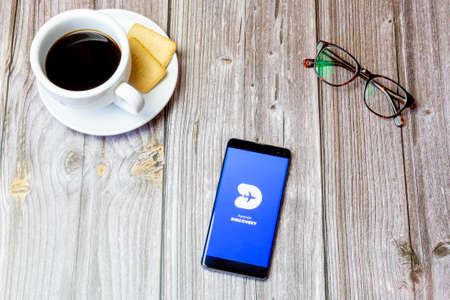 03-22-2021 Portsmouth, Hampshire, UK A mobile phone or cell phone laid on a wooden table with the Ryanair discovery app open on screenのeditorial素材