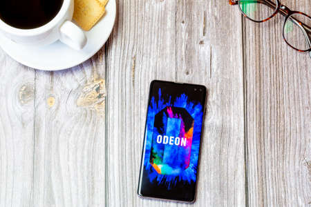 03-22-2021 Portsmouth, Hampshire, UK A mobile phone or cell phone laid on a wooden table with the Odeon Cinema app open on screenのeditorial素材