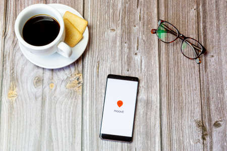 03-22-2021 Portsmouth, Hampshire, UK A mobile phone or cell phone laid on a wooden table with the Moovit app open on screenのeditorial素材