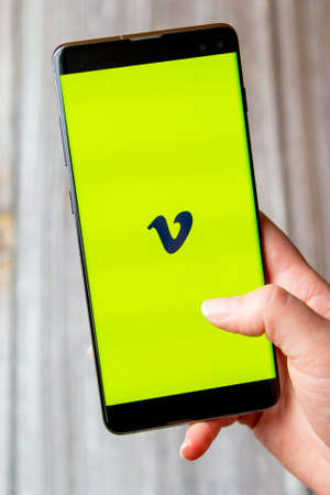 03-22-2021 Portsmouth, Hampshire, UK A mobile phone or cell phone being held in a hand with the Vimeo app open on screenのeditorial素材