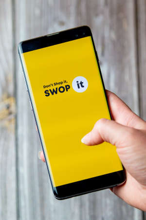 03-22-2021 Portsmouth, Hampshire, UK A mobile phone or cell phone being held in a hand with the Swop it app open on screenのeditorial素材