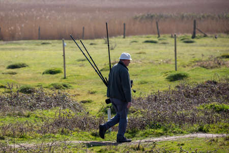 03-31-2021 Portsmouth, Hampshire, UK A wildlife photographer carrying equiptment through a nature...