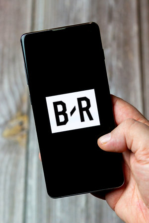 03-10-2021 Portsmouth, Hampshire, UK A Mobile phone or cell phone being held in a hand with the Bleacher Report app open on screenのeditorial素材