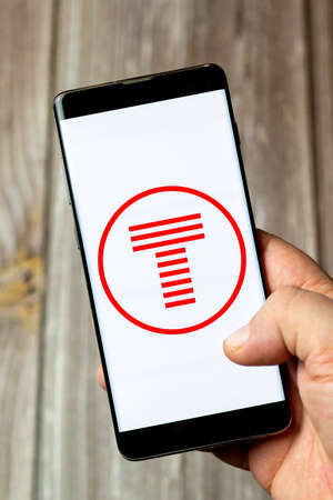 03-10-2021 Portsmouth, Hampshire, UK A Mobile phone or cell phone being held in a hand with the TFW app open on screenのeditorial素材