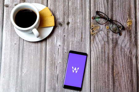 04-13-2021 Portsmouth, hampshire, UK A Mobile phone or cell phone laid on a wooden table showing the Wagestream app on screenのeditorial素材