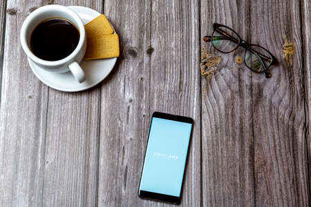 04-13-2021 Portsmouth, hampshire, UK A Mobile phone or cell phone laid on a wooden table showing the oriflame skin expert app on screenのeditorial素材