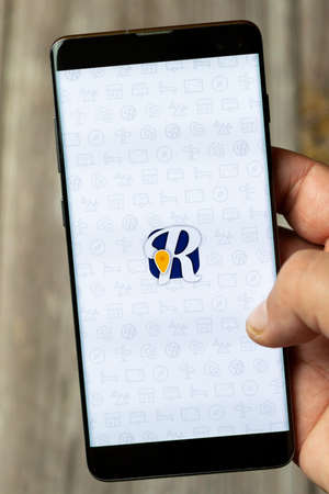 04-13-2021 Portsmouth, Hampshire, UK A Mobile phone or Cell phone being held in a hand showing the Roadtrippers app on screenのeditorial素材