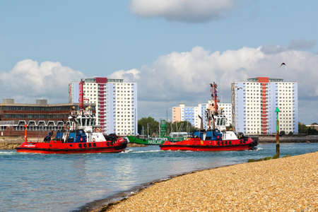 08-12-2021 Portsmouth, Hampshire, UK Two tugboats sailing into the entrance of Portsmouth Harbourのeditorial素材
