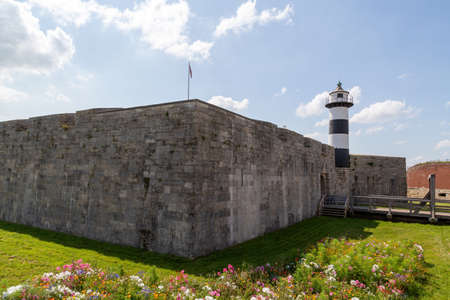 08-24-2021 Portsmouth, Hampshire, UK, The Exterior of Southsea Castle and lighthouse on a summer day with flowers in the foregroundのeditorial素材