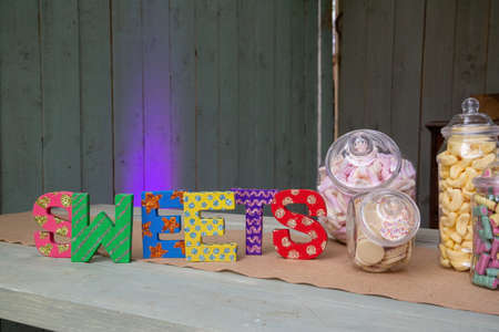 sweet jars filled with retro sweets next to a sign reading sweetsの写真素材