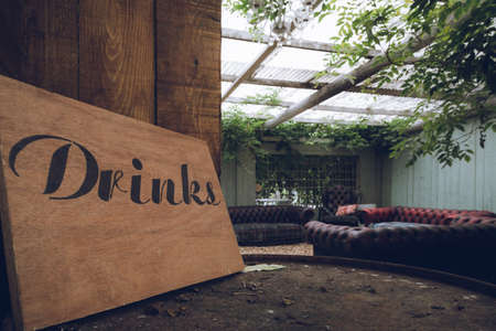 A rustic wooden sign in a bar reading drinksの写真素材