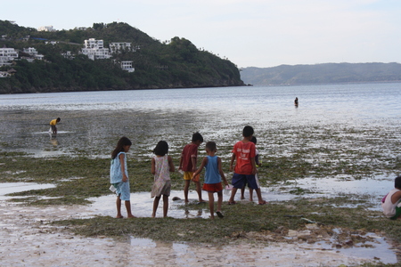 Children -playing on beach during low tideのeditorial素材
