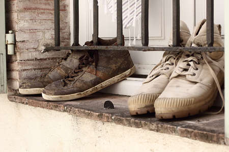 Muddy fashion trainers drying on a window sill. Vintage retro look.の写真素材