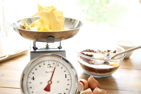 Butter being weighed for a chocolate cakeの写真素材