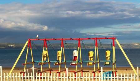 Beach swings lie unused as the sun sets over Weymouth beach