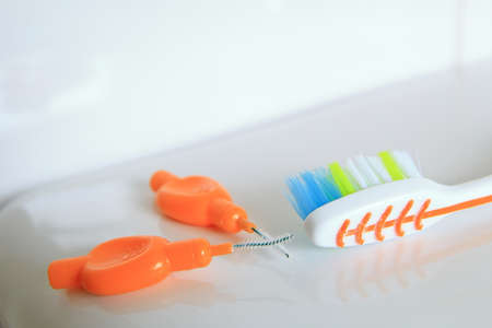 Shallow DOF shot of a toothbrush and interdental brushes on a shiny surfaceの写真素材