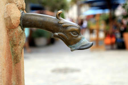 Gargoyle head on an old stone water fountainの写真素材
