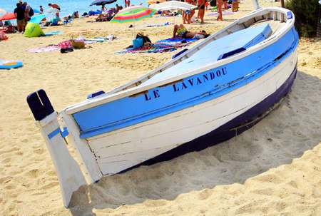 LE LAVANDOU, PROVENCE, FRANCE - AUGUST 17 2016: Colorful blue and white wooden boat on this French Riviera beach with the name of the town, Le Lavandou.のeditorial素材