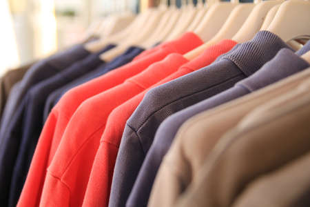 Shallow focus jackets on store rail, red, blue, grey, brown